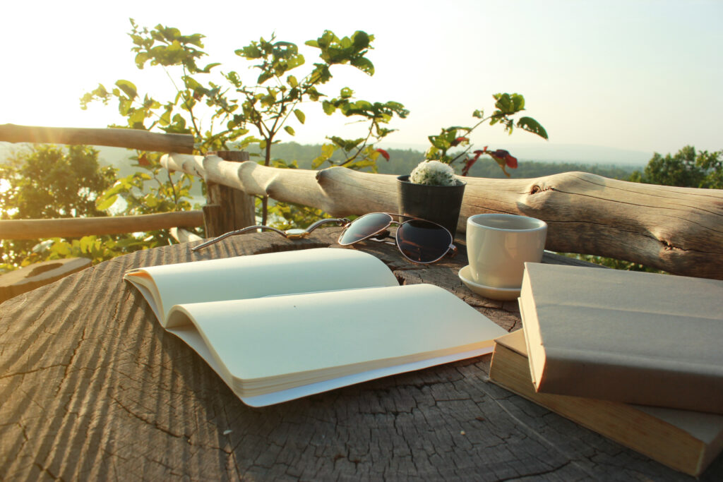 open-blank-diary-with-coffee-cup-wooden-table-balcony